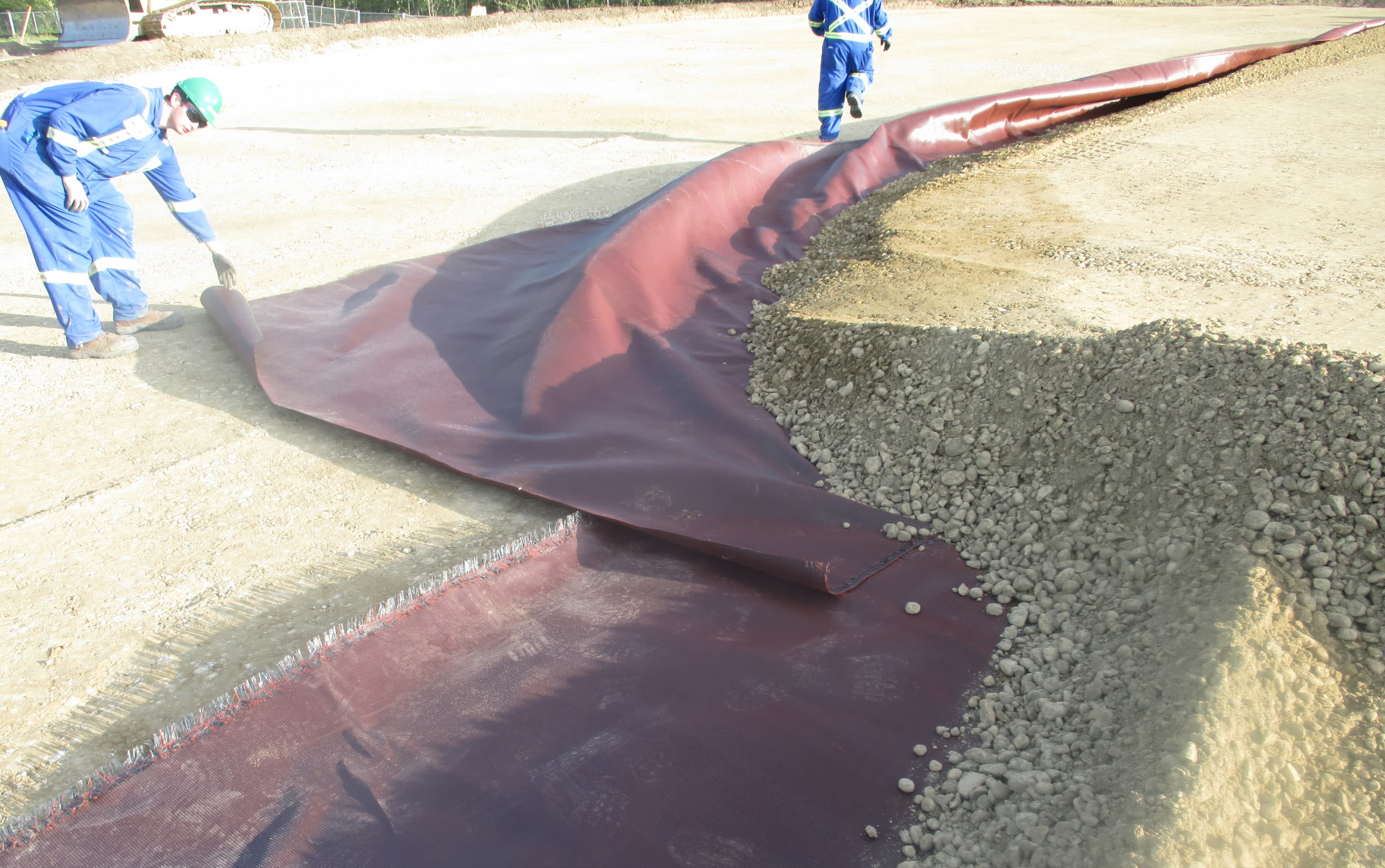 Contractor installing RSF layers with geotextile and fill material on site